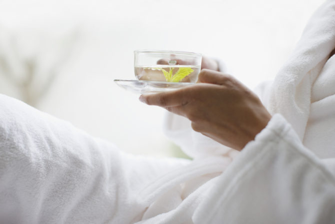 closeup of woman in spa wearing a robe and sipping water