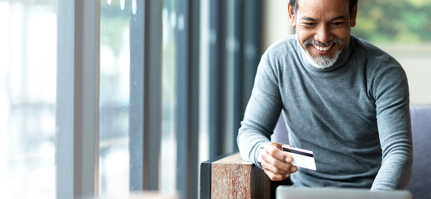 Senior man making credit card payment on computer